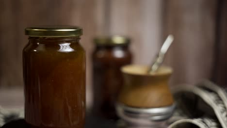 Close-up-of-rotating-mason-jar-of-peach-jam-with-"mate"-behind