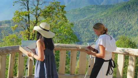 two artists painting scenic mountain view