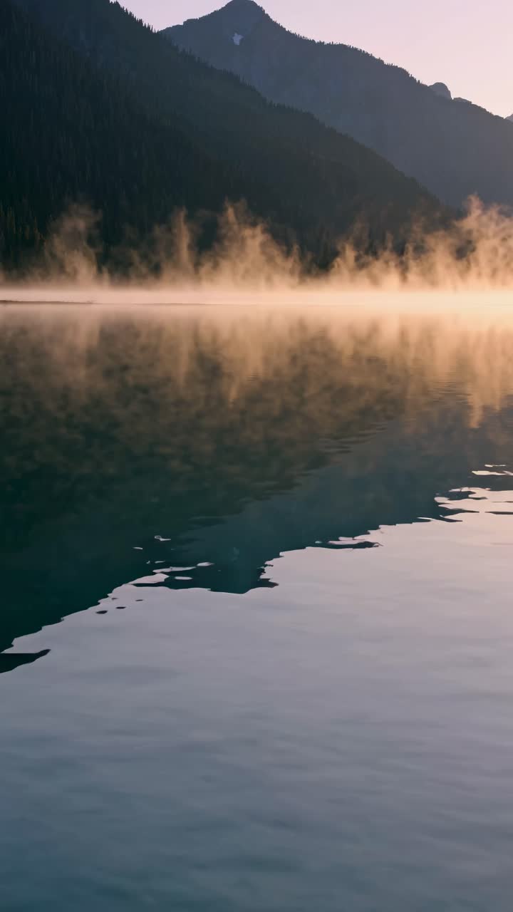 Serene lake at sunrise with mist rising, captured from a low angle