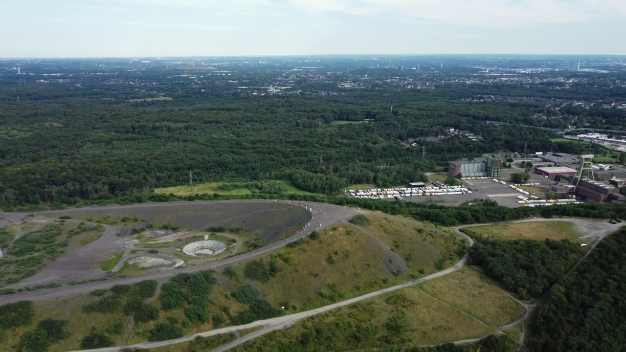 Aerial view of a landfill, forest and city