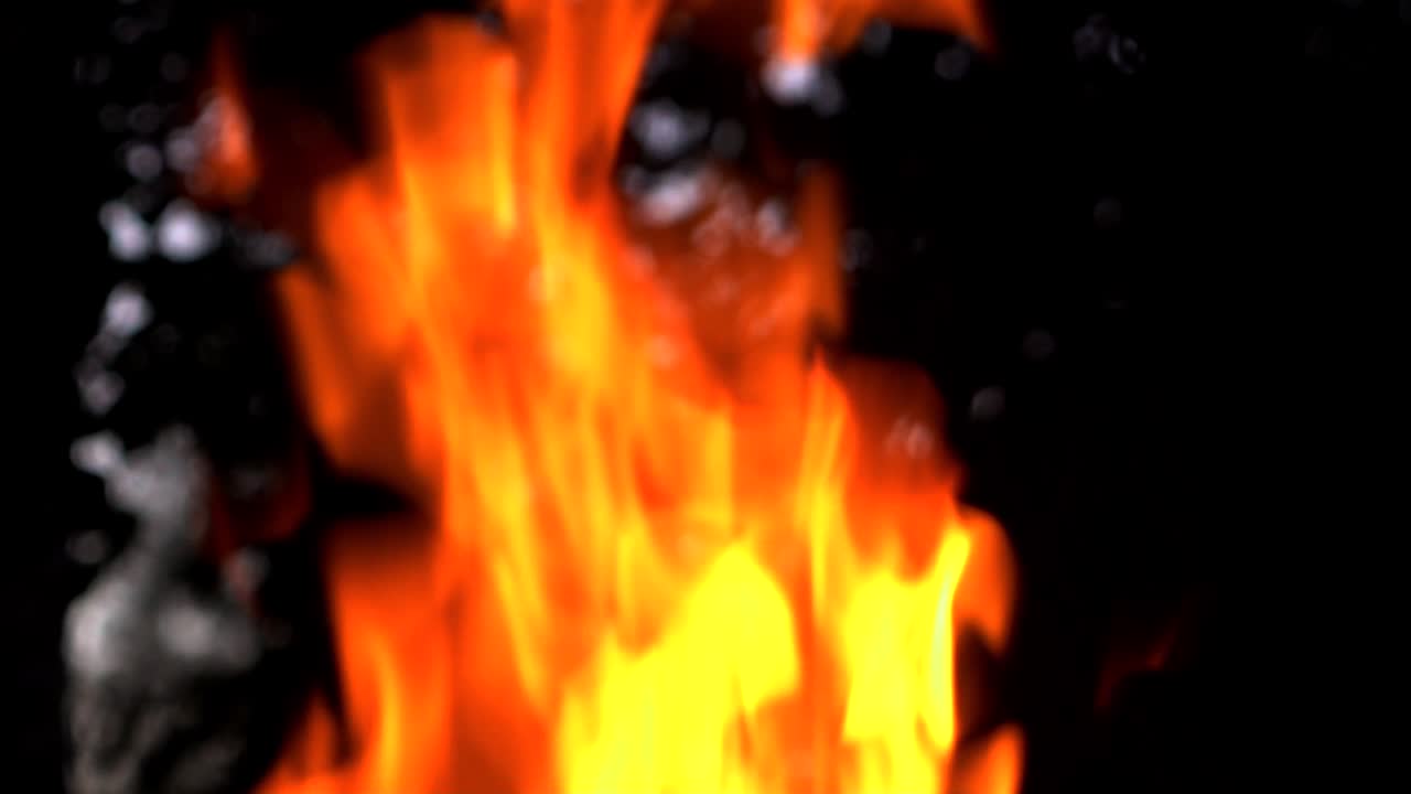 Slow motion of fire at bonfire in the dark, closeup