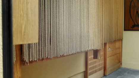 Slide-shot-of-drapes-hanging-on-the-doors-of-a-restaurant-in-Kyoto,-Japan-4K-slow-motion