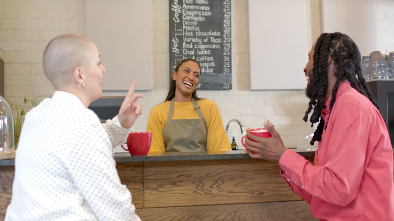 Una barista asiatica che anima la conversazione, gesticolando verso il menu e ridendo con i clienti al bancone