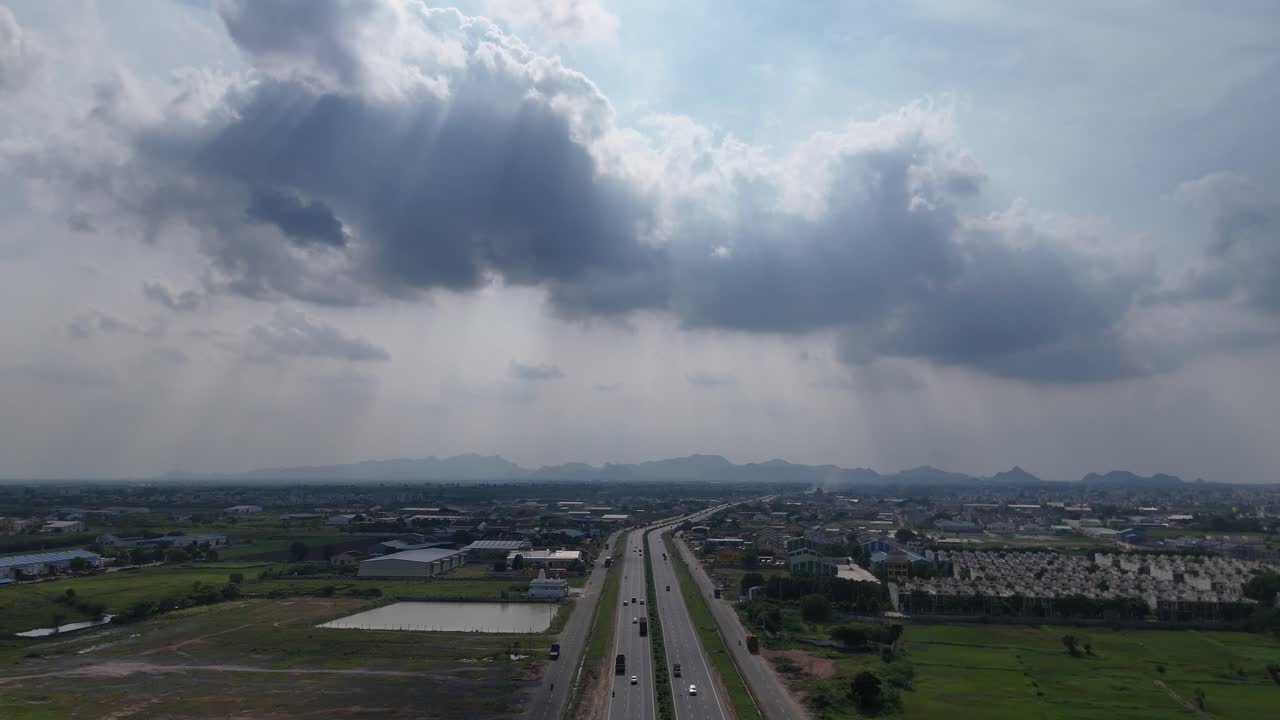 Drone shot of a rural road in Amaravathi, Vijayawada, surrounded by lush green fields.