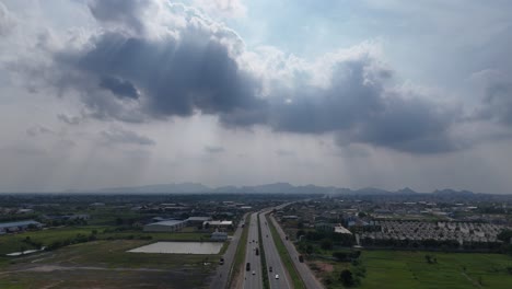 drone shot of a rural road in amaravathi, vijayawada, surrounded by lush green fields.