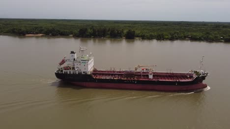 oil tanker navigating along amazon river. aerial sideways