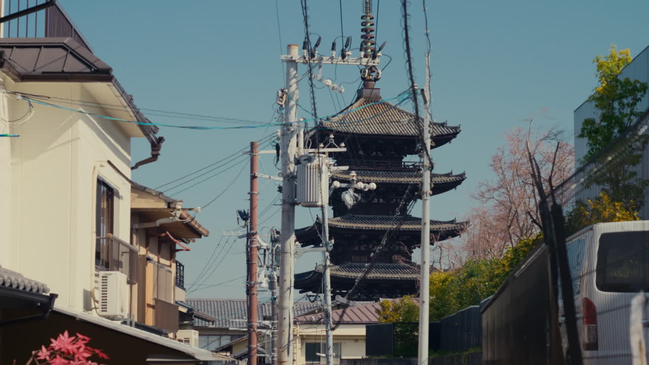 Otantik Kyoto sokağı, tarihi binalar ve tapınağa doğru yürüyen ziyaretçilerle birlikte.