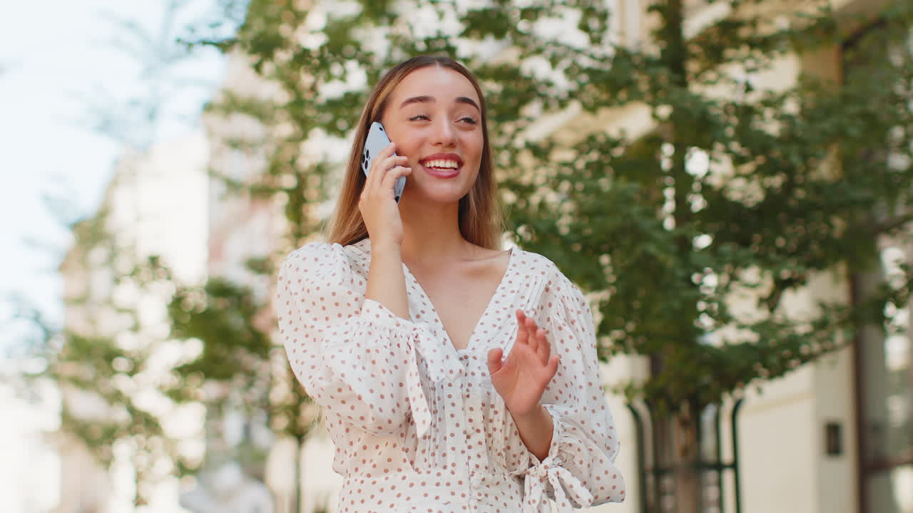 행복 한 여자 는 스마트폰 으로 즐거운 대화 를 하고 있으며, 도시 거리 에서 친구 들 과 대화 를 즐기고 있다