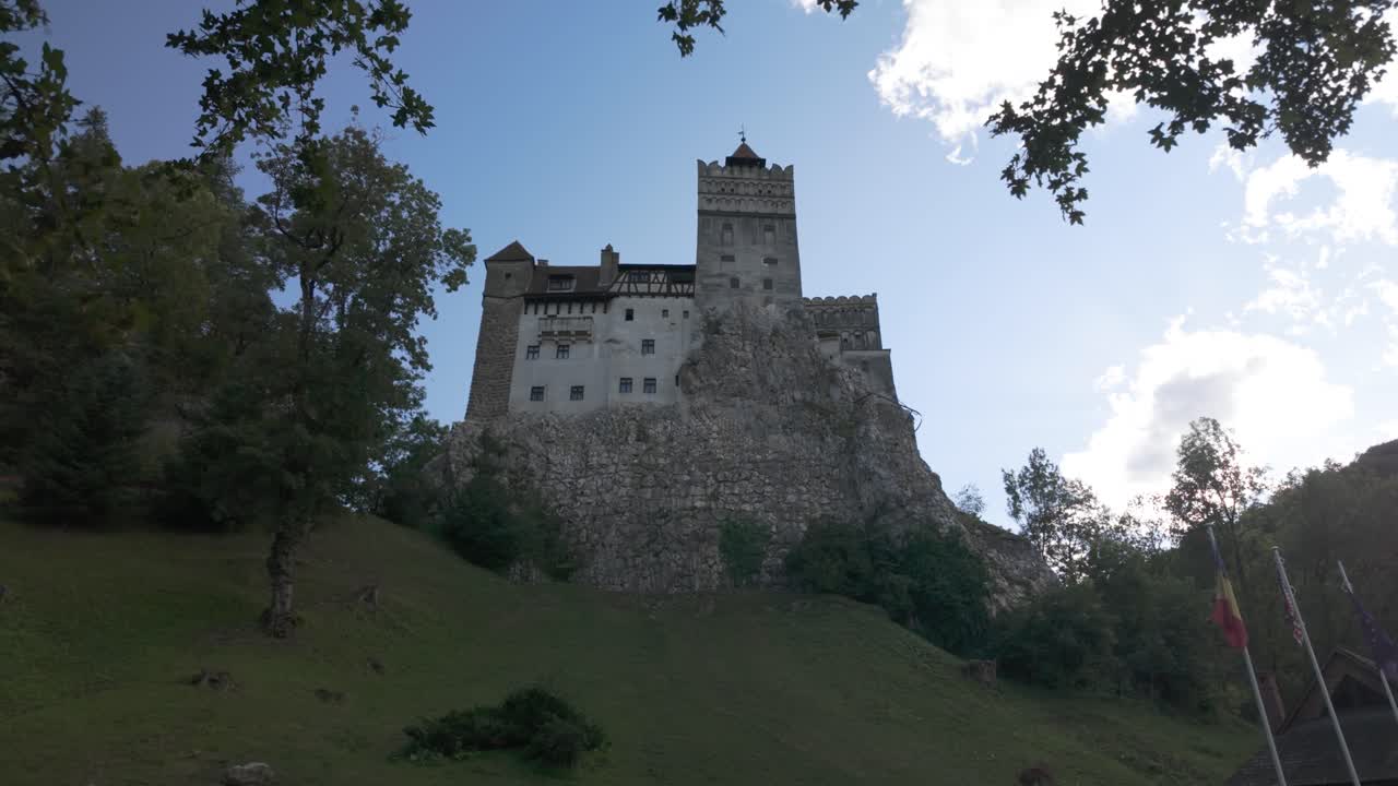 Bran Castle captured on its iconic hilltop, highlighted by the surrounding natural greenery and forest