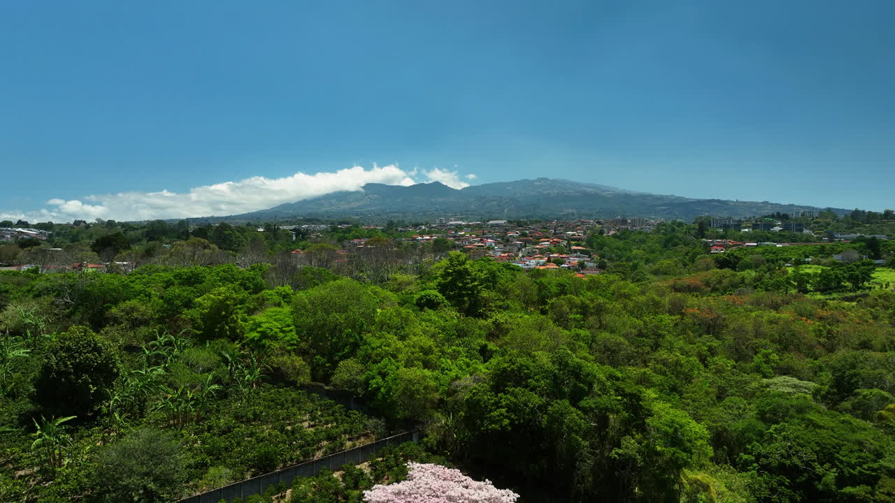 Aerial View of a City with a Volcano in the Background