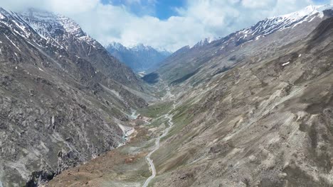 aerial drone shot capturing the expansive views of snow-dusted peaks and rocky slopes in ladakh.