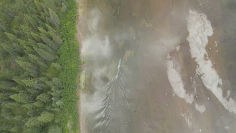 Stunning-bird's-eye-view-of-a-canoe-traveling-up-river-in-Labrador-Canada