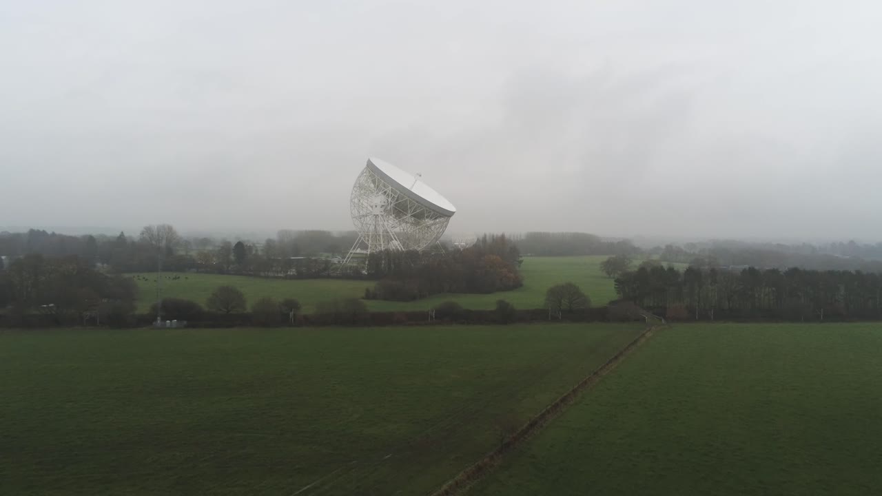 안개 낀 시골 시골을 가로질러 낮추는 공중 조드렐 뱅크 천문대 로벨 망원경