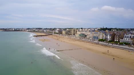 volando por la playa y mirando las fachadas de las casas junto al mar