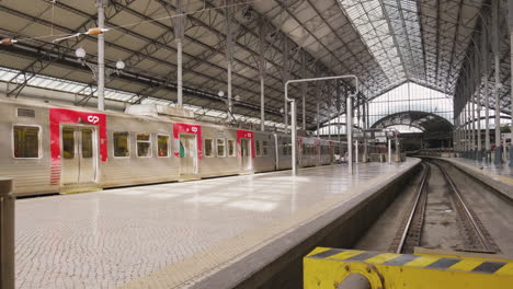 train with passengers at rossio railway station during covid-19 pandemic in lisbon, portugal. - wide shot