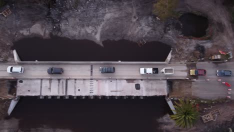 line of cars crossing dangerous bridge under construction in uruguay, south america