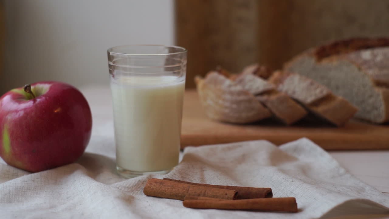 desayuno matutino. composición de alimentos en la mesa. manzana roja y vaso de leche.