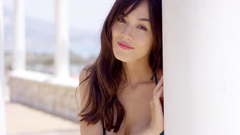 기둥 뒤에서 보고 서 있는 젊은 여자