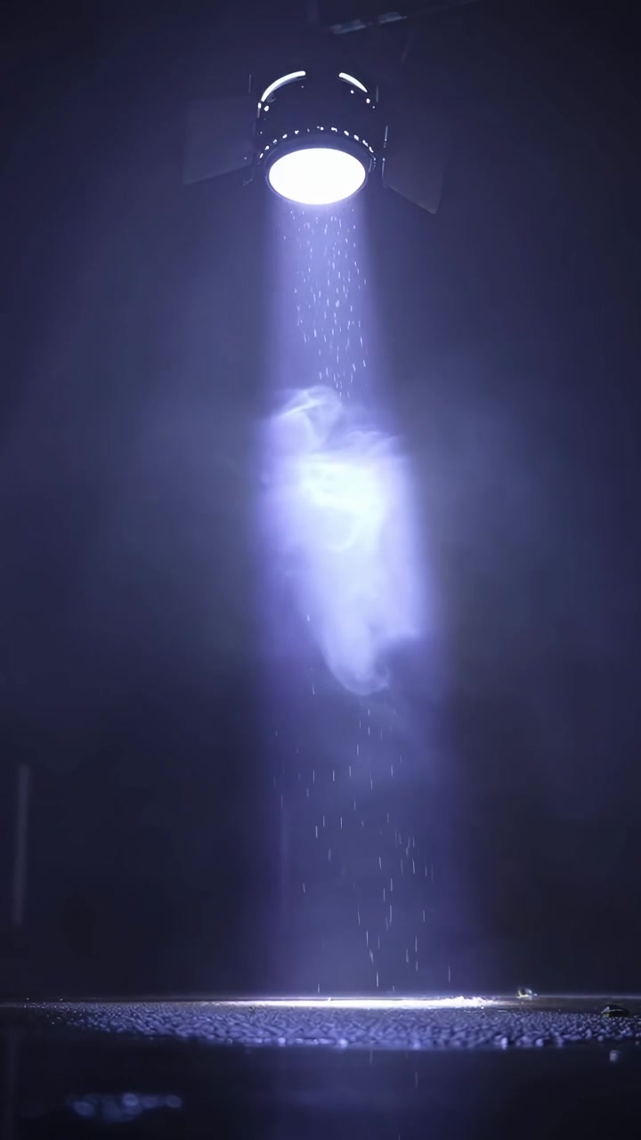 Dramatic Spotlight Illuminating Smoke and Falling Particles