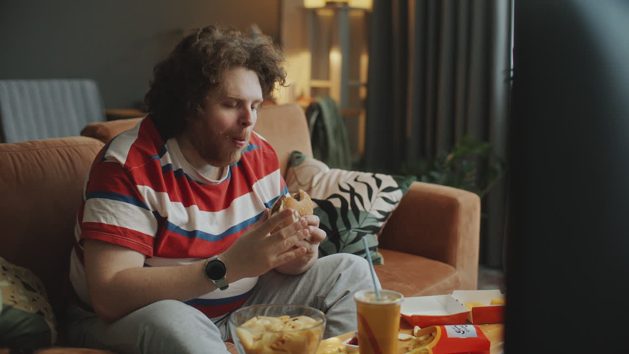 Man Eating Fast Food While Watching TV