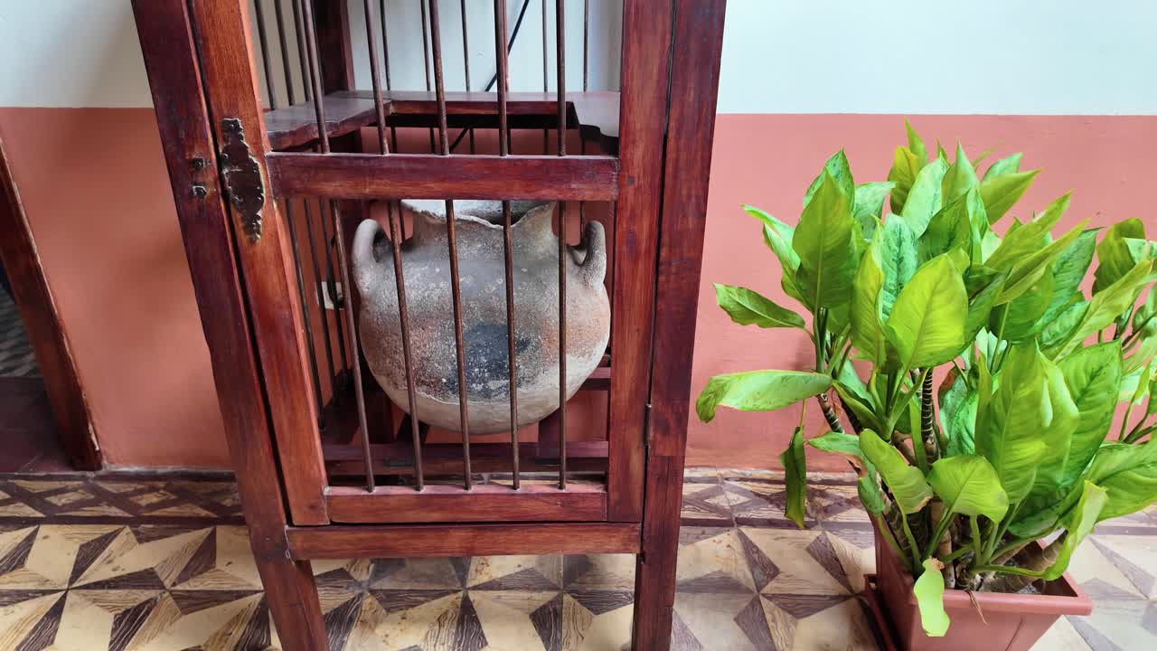 Authentic handheld view inside colonial patio, showcasing traditional tinajero clay pot used to keep drinking water cool and fresh