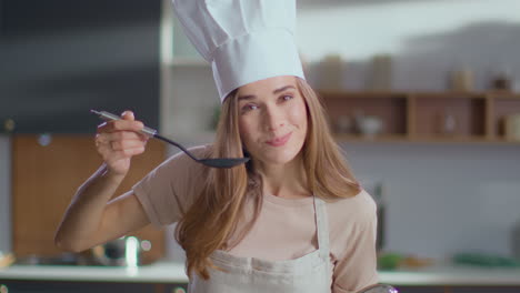 woman tasting soup in the kitchen