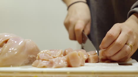 cerrar rebanar pollo crudo con un cuchillo en la cocina para la cena.