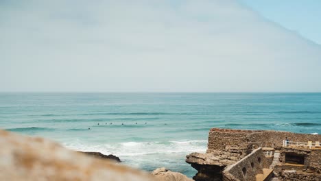 portugal guincho beach waves, cloudy day, near shore with surfers