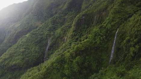 idyllic nature: tall wispy waterfalls on rugged lush jungle mountains