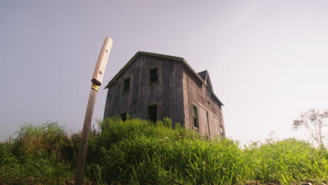 Niedriger-Winkel-Mit-Blick-Auf-Das-Graue,-Verwitterte-Scheunenhaus-Aus-Holz,-Sonniger-Tag