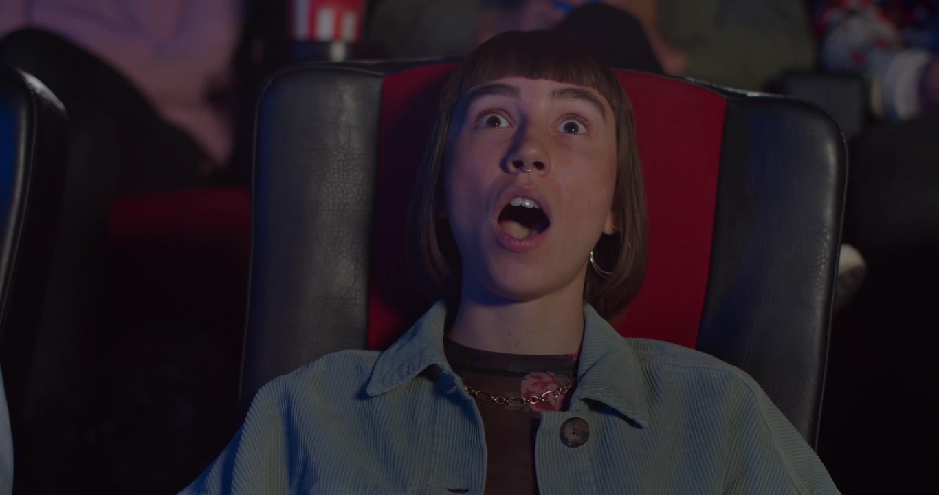 Jovem Mulher Assistindo a um Filme Num Cinema