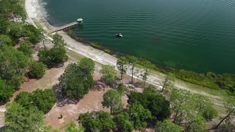 Exuberantes-árboles-Verdes-Y-Muelle-De-Madera-En-La-Orilla-Del-Lago-Defuniak-En-Defuniak-Springs,-Florida