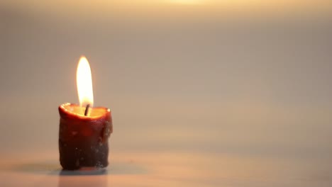 Single-candle-flickers-with-reflections