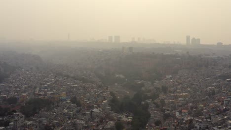 Toma-Aérea-De-Grandes-Asentamientos-Urbanos-En-Barrancos-En-Un-Día-Muy-Contaminado-En-La-Ciudad-De-México