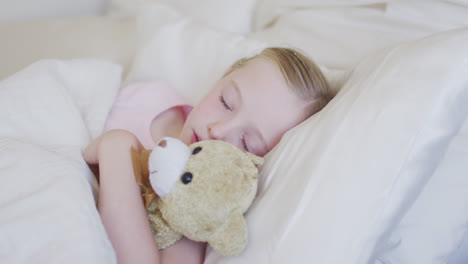 Side-view-of-Caucasian-girl-sleeping-on-bed-