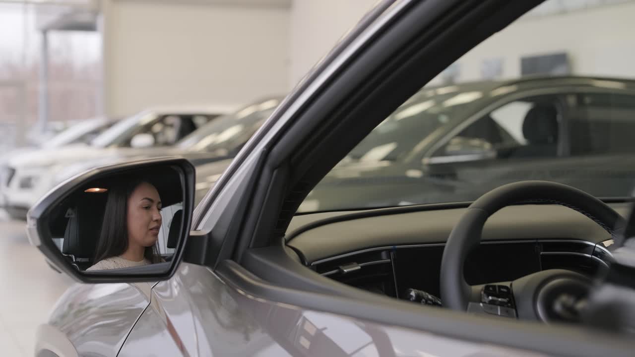 mujer eligiendo un coche en una sala de exposición de automóviles