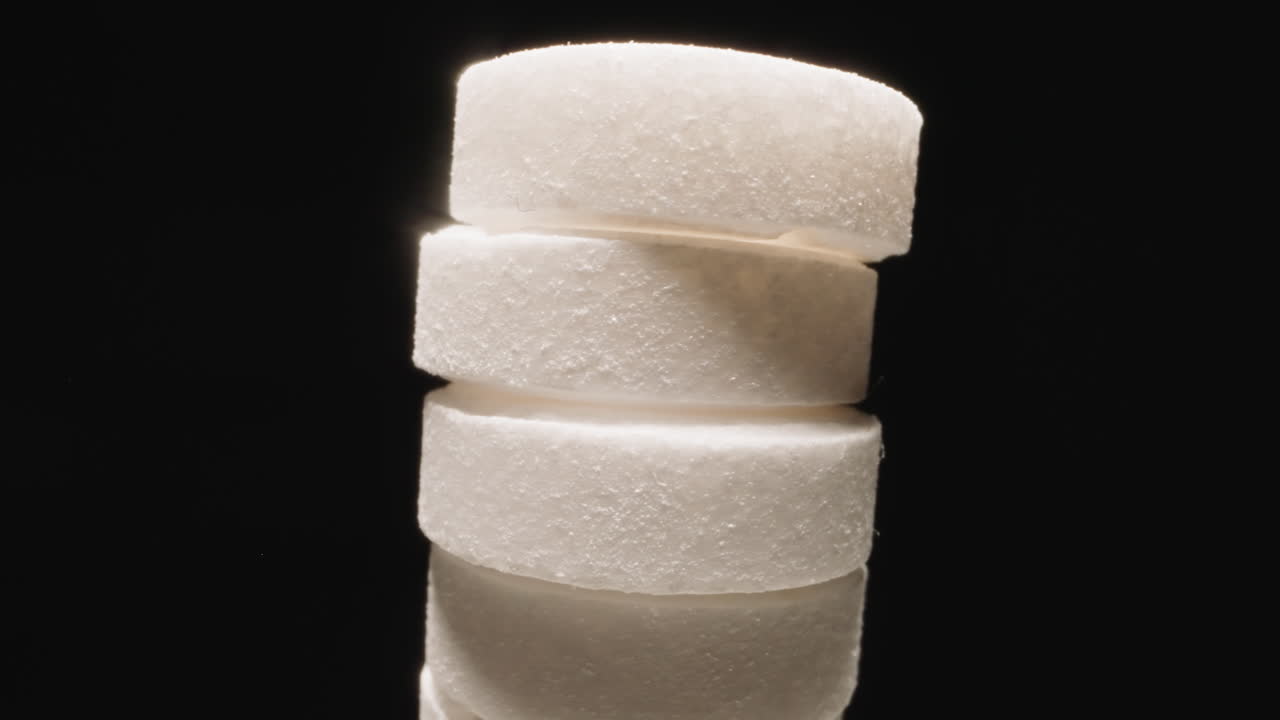 pastillas redondas blancas apiladas rotando sobre un fondo negro