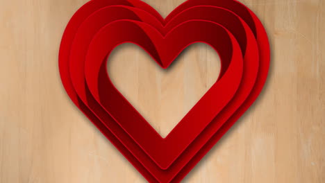 red layered heart animation over wooden background, symbolizing love and romance