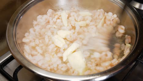 Butterklumpen-Auf-Frischen,-Dampfenden-Kleinen-Garnelen-In-Einem-Silbernen-Topf-Mischen