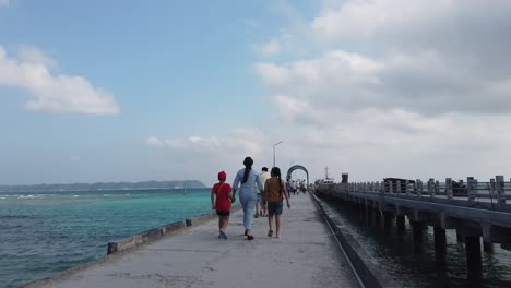 a man leads his two children by the hand along a ferry jetty on their holiday in the andaman islands in india towards a ferry to transport them to another island