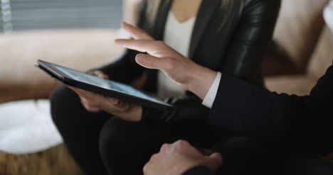 Extreme-Close-Up-Of-Business-Woman-Hands-Using-Tablet-Computer-On-A-Meeting