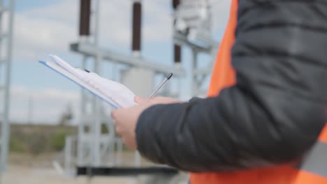 an engineer supervises the construction of a transformer substation