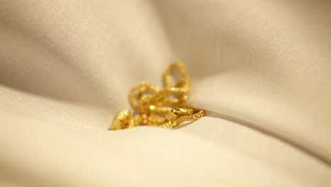 gold wedding necklace dropped on velvet cloth