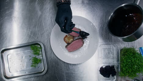 the cook pours sauce on roasted beef steak