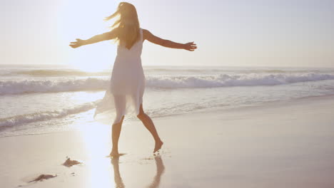 free happy woman spinning arms outstretched enjoying nature dancing on beach at sunset slow motion red dragon