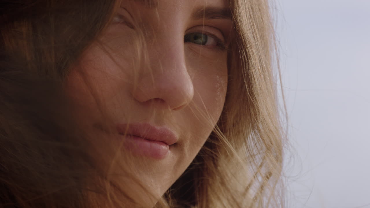 retrato de cerca de una mujer hermosa sonriendo disfrutando de la playa relajándose en la orilla del mar el viento soplando el cabello explorando un estilo de vida tranquilo y despreocupado