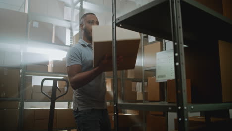 african american inventory specialist walks in warehouse retail facility scans parcels african american inventory specialist walks in warehouse retail facility scans parcels with ecommerce online orders checks delivery information on tablet computer sorting center of postal service