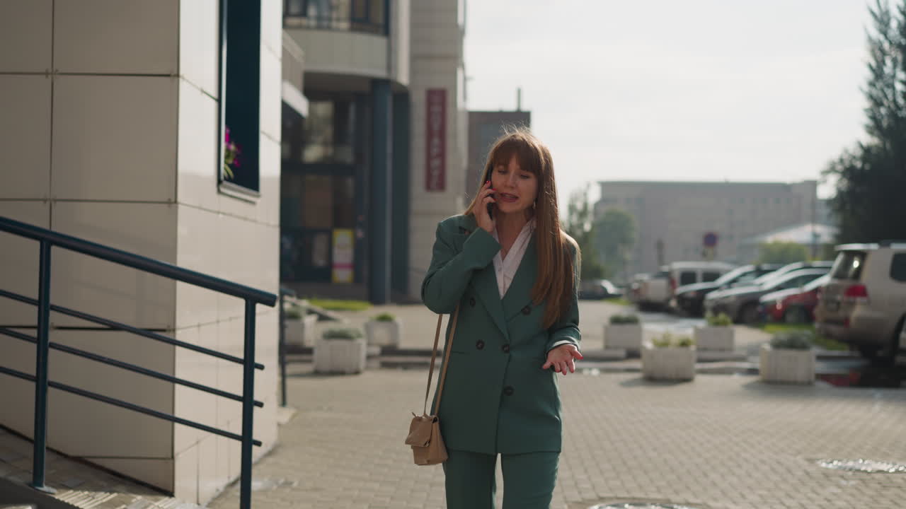 Annoyed woman shouts into mobile phone walking down street