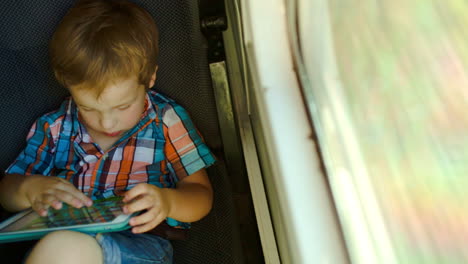 boy in train using tablet computer