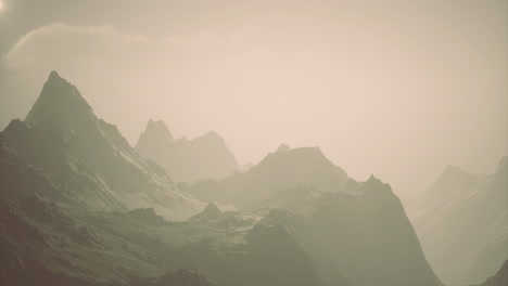 majestic mountain range under a soft hazy sky during sunrise